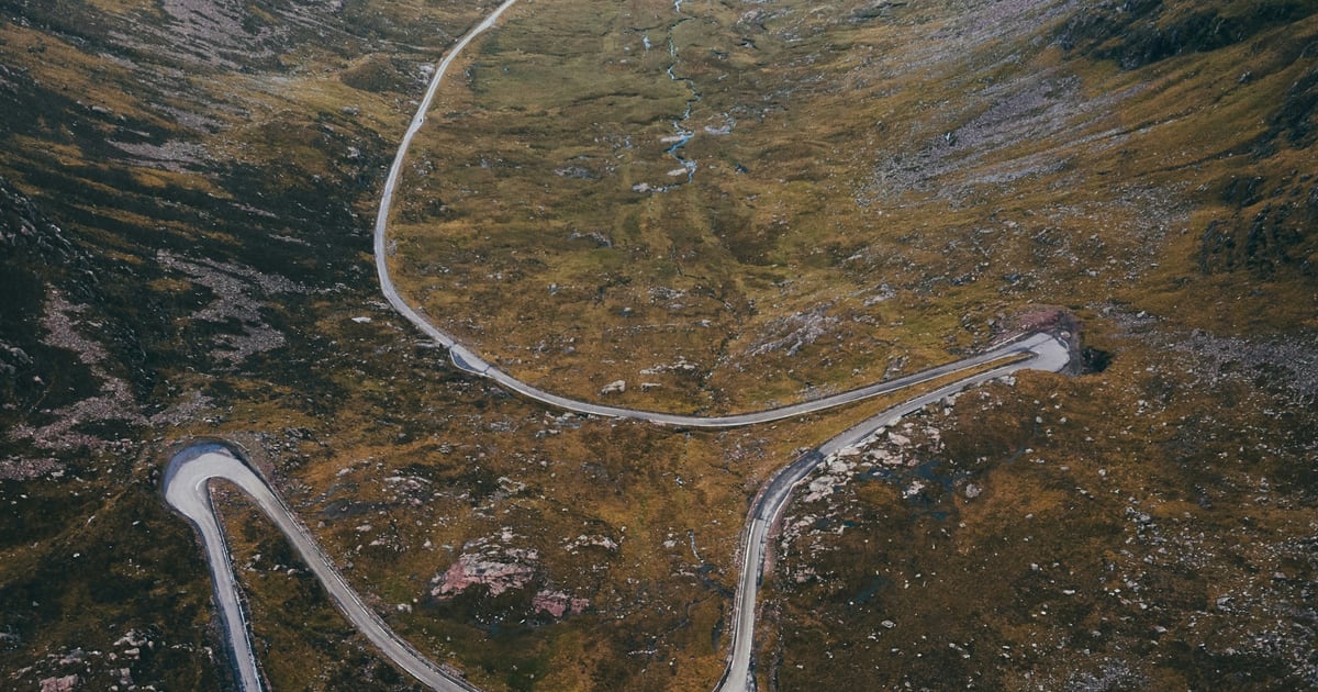 Aerial view of a mountain road that doubles back on itself in a series of hairpin bends